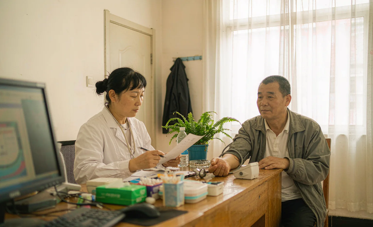 护士为慢病患者建立健康档案并测量血压